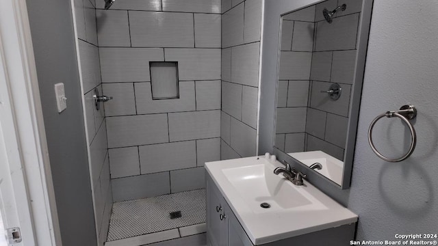 bathroom with vanity and a tile shower