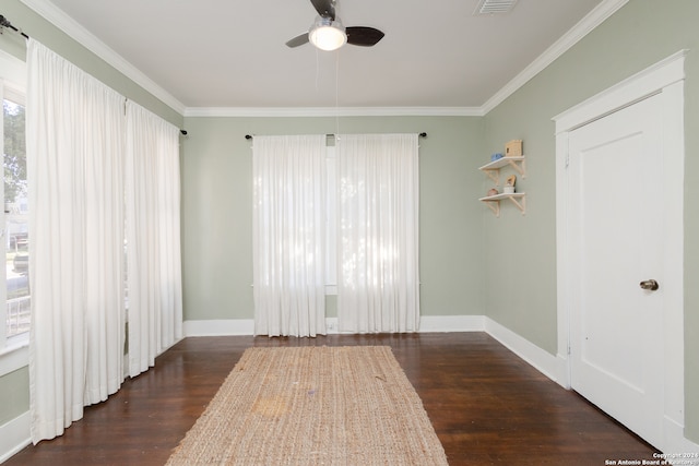 empty room featuring dark wood-type flooring, ceiling fan, and ornamental molding