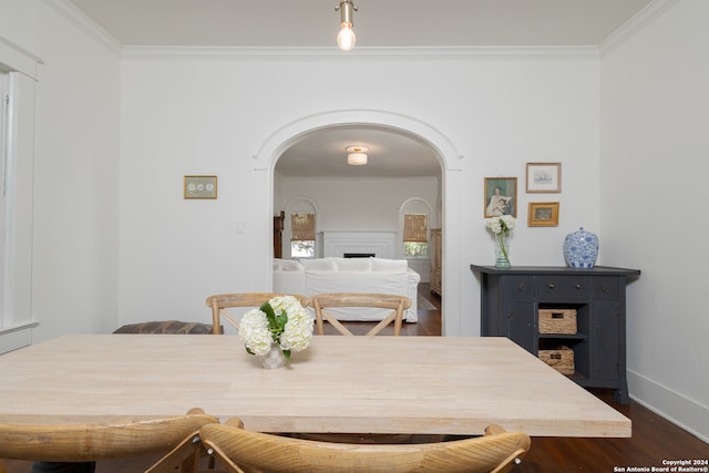 dining space featuring dark wood-type flooring and crown molding