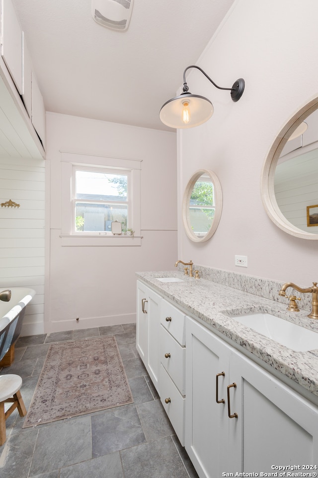 bathroom with vanity, a tub to relax in, and wooden walls