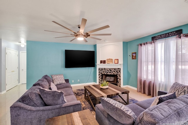 living room with ceiling fan and a fireplace