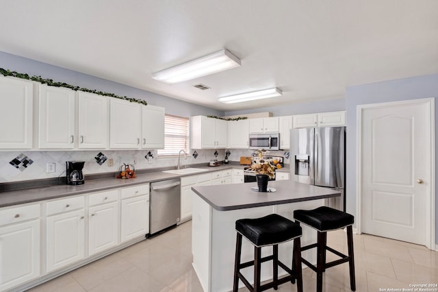 1336 Leopard Hunt, San Antonio, TX 78251 - kitchen with appliances with stainless steel finishes, a breakfast bar, white cabinetry, sink, and a center island