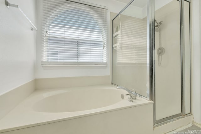 bathroom featuring shower with separate bathtub