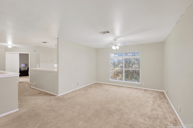 empty room featuring light colored carpet and ceiling fan