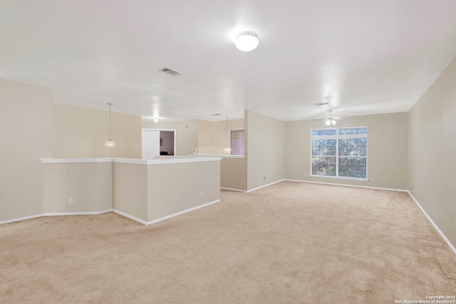 unfurnished living room with ceiling fan and light colored carpet