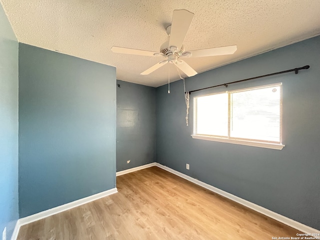 empty room with light hardwood / wood-style flooring, a textured ceiling, and ceiling fan