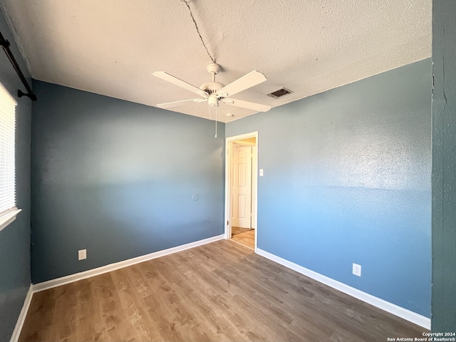 unfurnished room with ceiling fan, a textured ceiling, and hardwood / wood-style floors