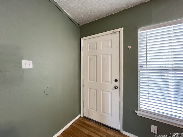 doorway to outside featuring hardwood / wood-style floors and a textured ceiling