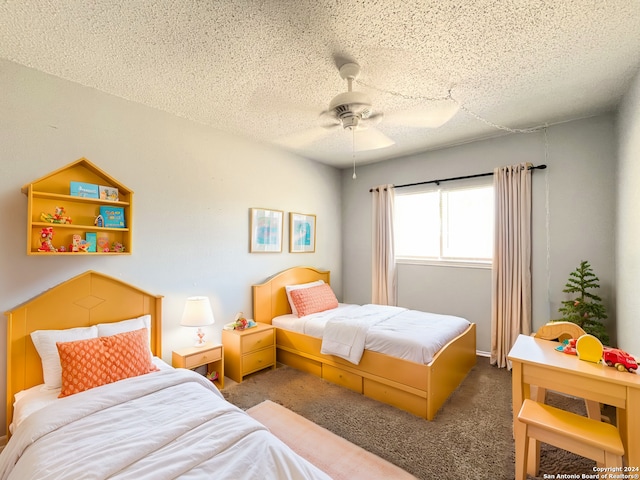 carpeted bedroom with ceiling fan and a textured ceiling