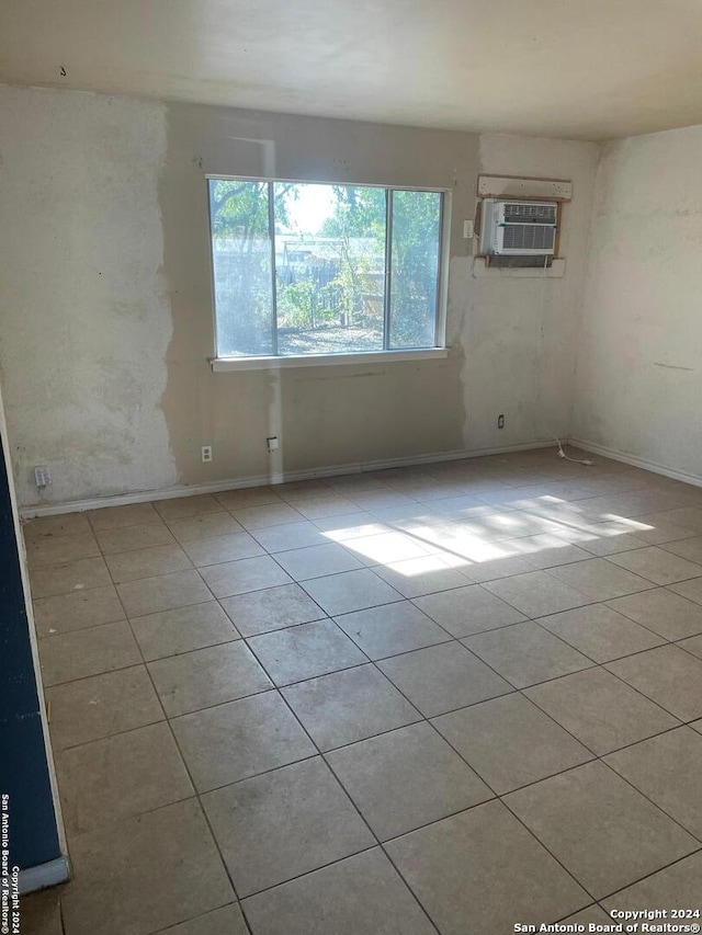 empty room with light tile patterned floors and a wall unit AC