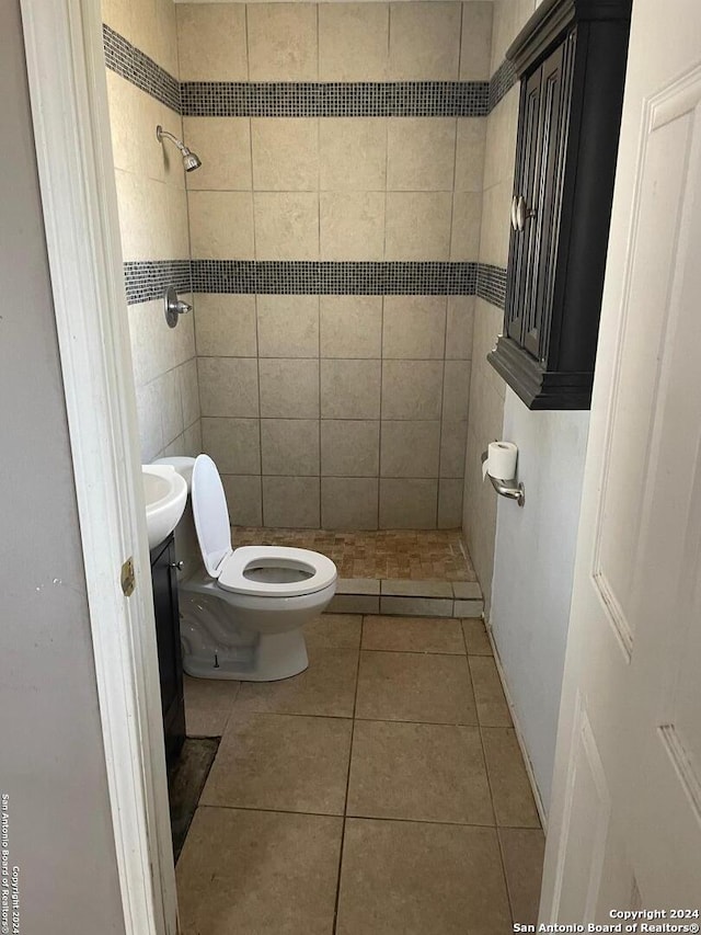 bathroom with tiled shower, toilet, and tile patterned floors