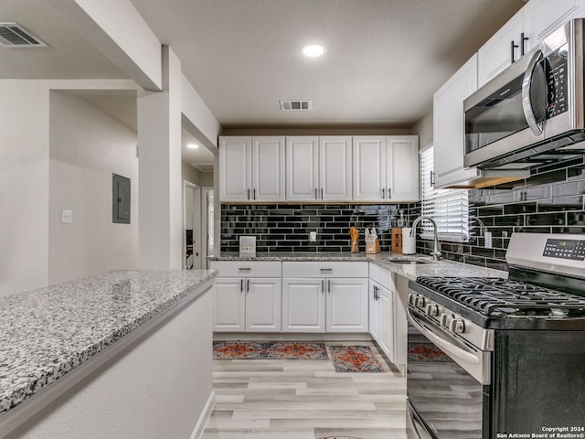 kitchen with white cabinetry, tasteful backsplash, stainless steel appliances, and sink