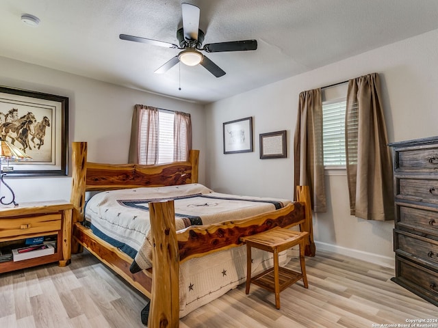 bedroom with ceiling fan, a textured ceiling, and light hardwood / wood-style flooring