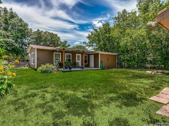 rear view of property with a patio area and a yard