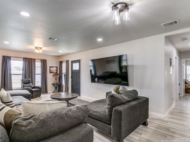 living room featuring light hardwood / wood-style floors and a textured ceiling