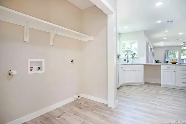 clothes washing area featuring hookup for a washing machine, electric dryer hookup, light hardwood / wood-style floors, and a healthy amount of sunlight