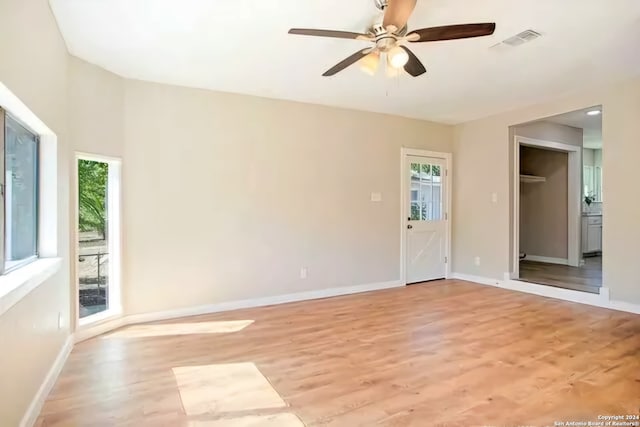 spare room with ceiling fan, a healthy amount of sunlight, and light hardwood / wood-style flooring