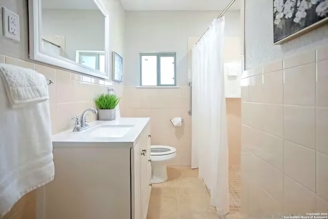 bathroom featuring curtained shower, tile patterned flooring, toilet, vanity, and tile walls