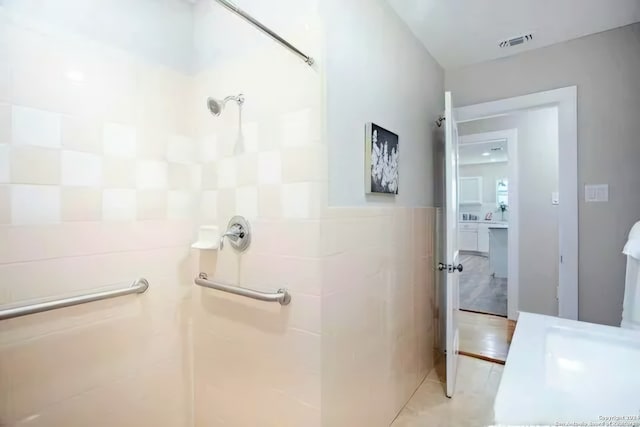 bathroom featuring tile patterned flooring and tile walls