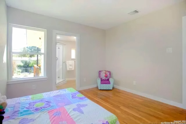 bedroom with hardwood / wood-style flooring and multiple windows