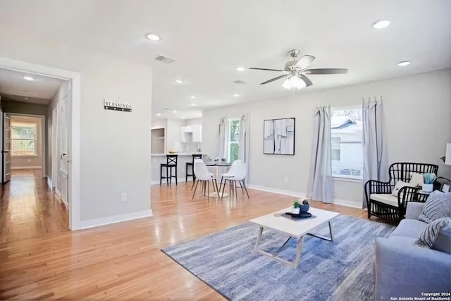 living room featuring light hardwood / wood-style flooring and ceiling fan