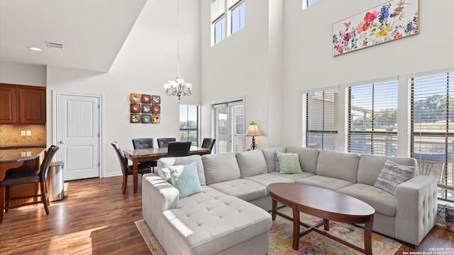 living room with a chandelier, dark hardwood / wood-style floors, and a high ceiling