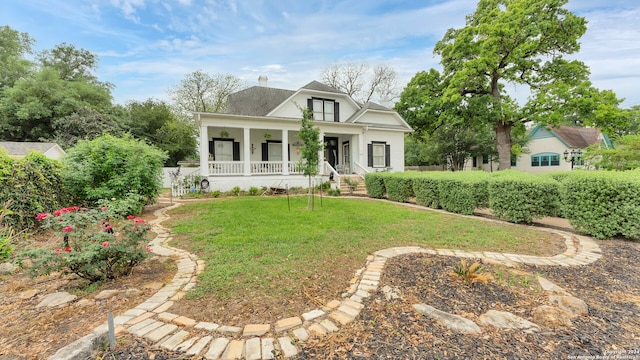 view of front of house with a front yard and a porch