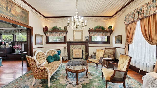 sitting room with crown molding, an inviting chandelier, and dark hardwood / wood-style flooring