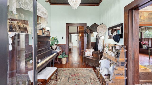 misc room with ornamental molding, a chandelier, dark hardwood / wood-style floors, and wood walls