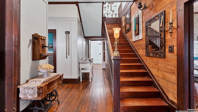 stairway featuring wooden walls and hardwood / wood-style floors