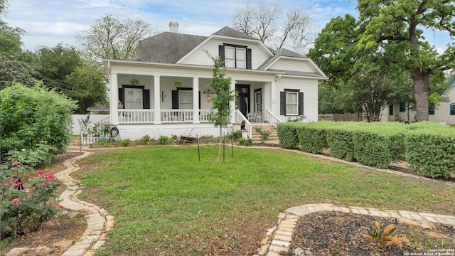 view of front of home featuring covered porch and a front lawn