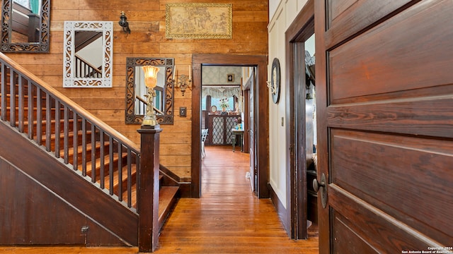 interior space with hardwood / wood-style flooring and wood walls