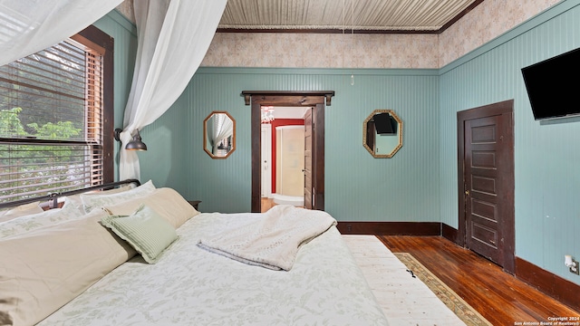 bedroom featuring crown molding and dark hardwood / wood-style flooring