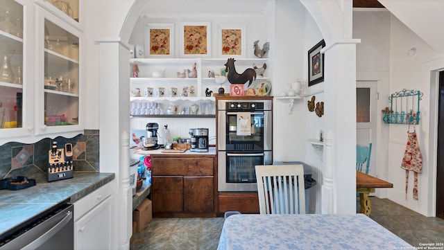 kitchen with tile patterned floors, decorative backsplash, white cabinets, and stainless steel appliances