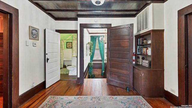 interior space with beam ceiling, wood walls, wooden ceiling, and dark hardwood / wood-style flooring