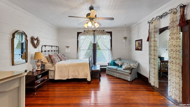 bedroom with wooden ceiling, dark wood-type flooring, wooden walls, and ceiling fan