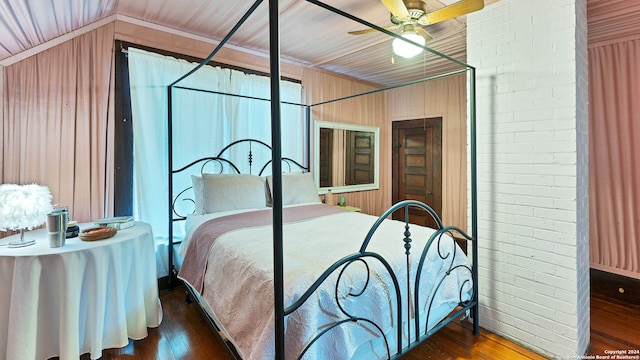 bedroom with dark hardwood / wood-style floors, brick wall, vaulted ceiling, and ceiling fan