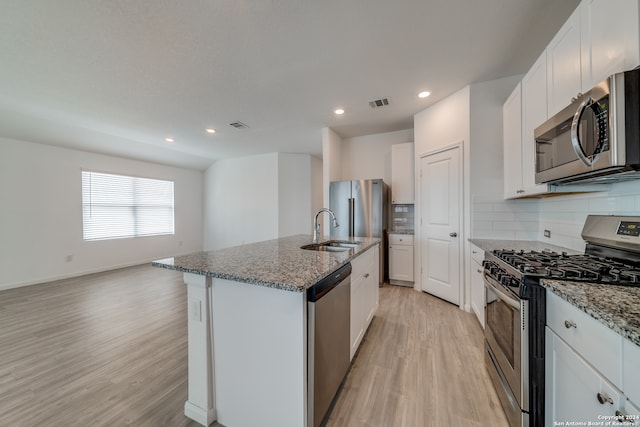 kitchen featuring a kitchen island with sink, sink, white cabinets, light wood-type flooring, and appliances with stainless steel finishes