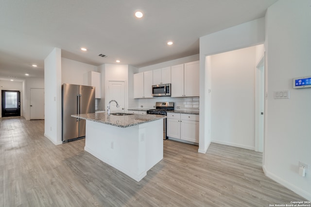 kitchen featuring a center island with sink, white cabinetry, light hardwood / wood-style flooring, sink, and stainless steel appliances