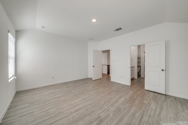 unfurnished bedroom with lofted ceiling and light hardwood / wood-style floors