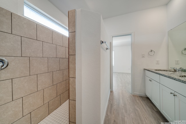 bathroom featuring vanity, hardwood / wood-style floors, and tiled shower