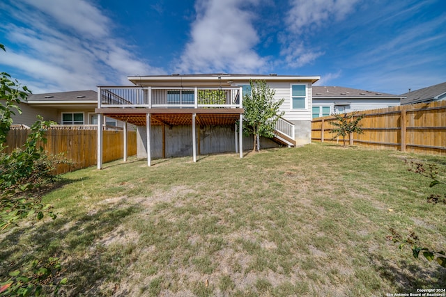 back of property with a deck and a yard