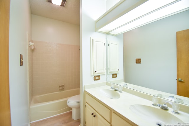 full bathroom featuring shower / tub combination, a textured ceiling, wood-type flooring, toilet, and vanity