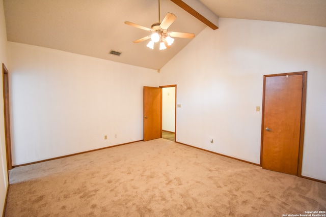 spare room featuring light carpet, beamed ceiling, high vaulted ceiling, and ceiling fan