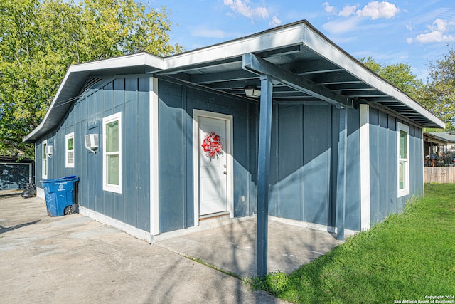 view of property exterior featuring a patio area and a lawn