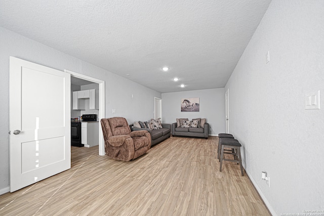 living room with a textured ceiling and light wood-type flooring