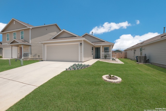 view of front of property with central air condition unit, a front yard, and a garage