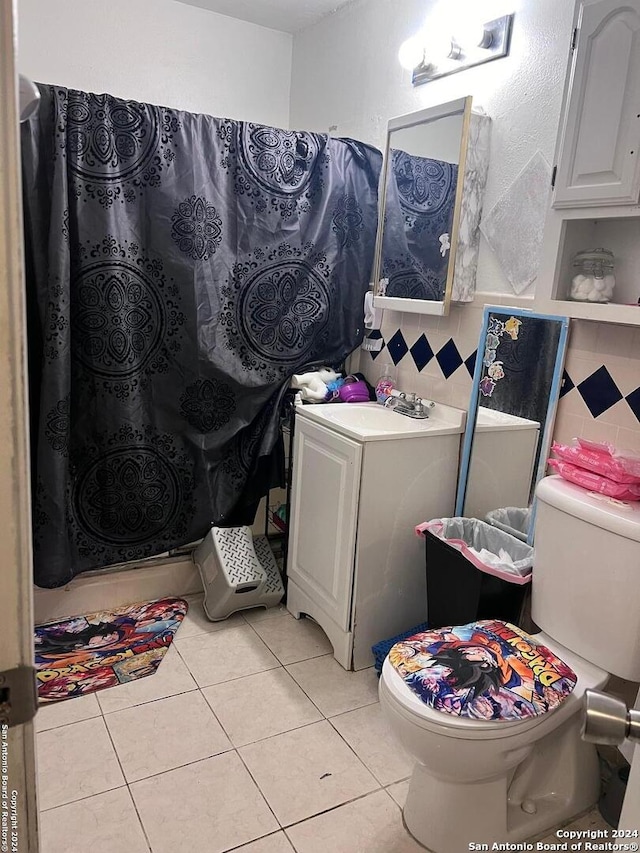 bathroom featuring vanity, toilet, decorative backsplash, and tile patterned flooring