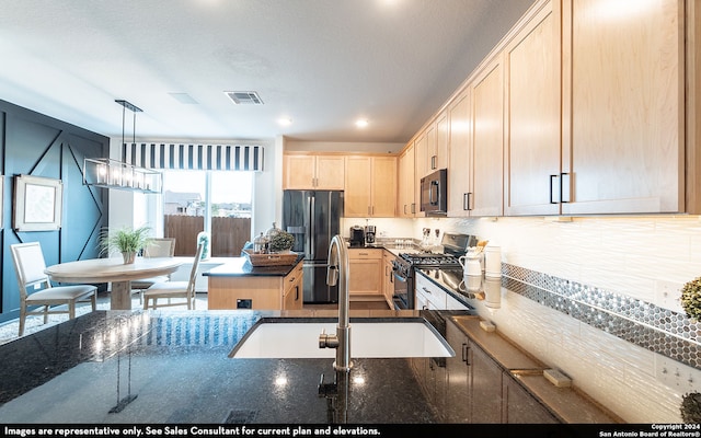 kitchen featuring light brown cabinets, hanging light fixtures, sink, appliances with stainless steel finishes, and tasteful backsplash