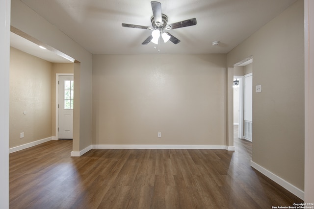 empty room featuring ceiling fan and dark hardwood / wood-style flooring